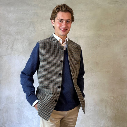 Slim Cut Nehru Style Gilet in Mist Check Lovat Tweed. This waistcoat is made up in a wonderful cross pattern of dark blue-black, brown and teal over a misty grey. Woven by Lovat Mill this is an incredibly warm and well-made tweed. Cut Made and Finished by Hand in London. Entirely made in Great Britain. Worn over blue jersey.