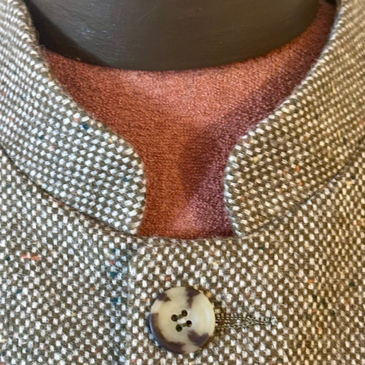 Nehru Style Gilet in a Hopsack patterning that gives the overall effect of a misty green. With a weight that will take you from early autumn through until late Spring, this smart tweed will quickly pay its way.
Lined in Cotton Ticking this waistcoat has Flat Horn buttons and a Mandarin collar.
A superb alternative to a jacket or jumper for the cooler days and nights with a slim, tailored cut and ample pocket space. Warm and easy to wear, it will work as well inside 