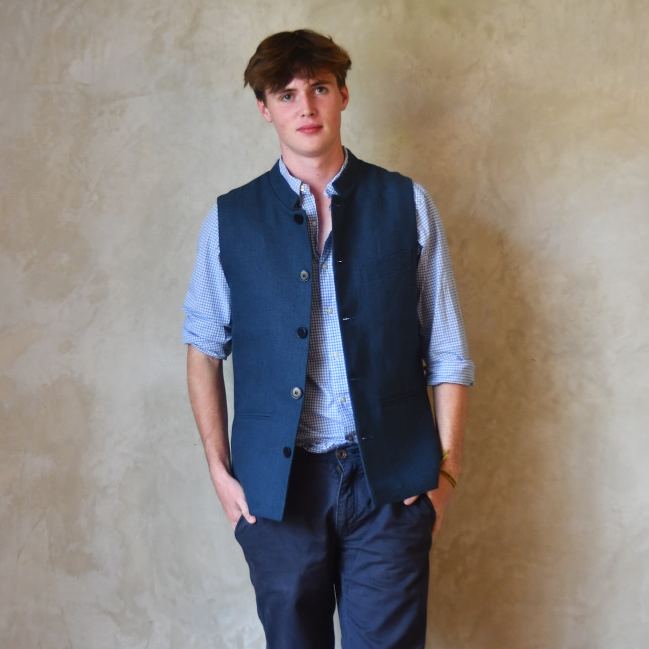 Navy Linen Slim Cut Gilet. A bespoke Pure Irish Linen waistcoat, handmade in London. Lined in pure cotton ticking with a Nehru collar. Worn over a blue shirt, Full length view.