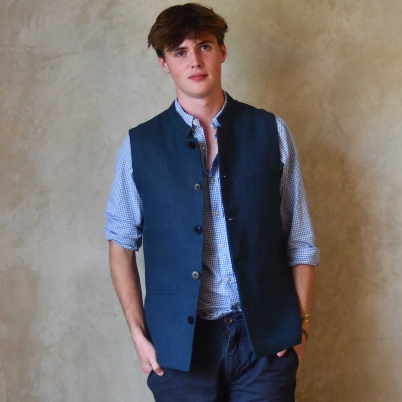 Navy Linen Fitted Cut Waistcoat. A bespoke Pure Irish Linen waistcoat, handmade in London. Lined in pure cotton ticking with a Nehru collar. Worn unbuttoned over a blue shirt, Full length view.