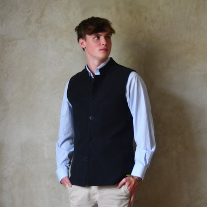 Nehru style gilet in navy moleskin. A bespoke loose fit gilet in a pure cotton navy moleskin fabric handmade for you in London. Shown worn buttoned up over blue shirt.