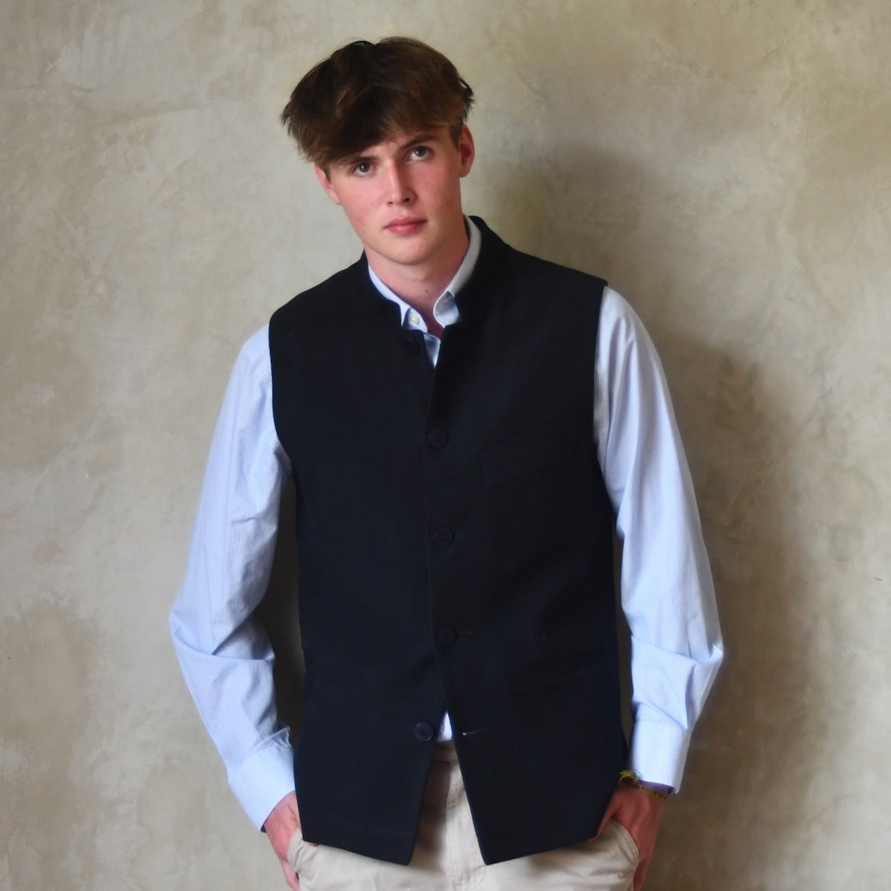Nehru style gilet in navy moleskin. A bespoke loose fit gilet in a pure cotton navy moleskin fabric handmade for you in London. Shown worn closed over blue shirt.