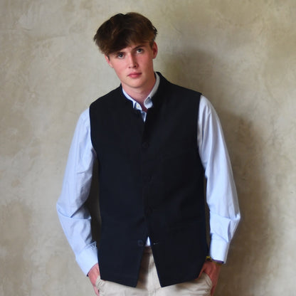 Nehru style gilet in navy moleskin. A bespoke loose fit gilet in a pure cotton navy moleskin fabric handmade for you in London. Shown worn closed over blue shirt.