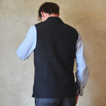 Rear view of Nehru style gilet in navy moleskin. A bespoke slim-fit gilet in a pure cotton navy moleskin fabric handmade for you in London. Shown worn over blue shirt.