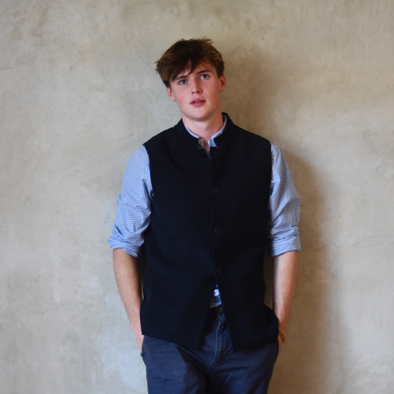 Nehru style gilet in navy moleskin. A bespoke slim-fit gilet in a pure cotton navy moleskin fabric handmade for you in London. Shown worn closed over blue shirt.