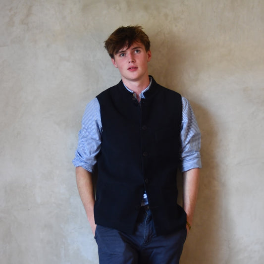 Nehru style gilet in navy moleskin. A bespoke slim-fit gilet in a pure cotton navy moleskin fabric handmade for you in London. Shown worn closed over blue shirt.