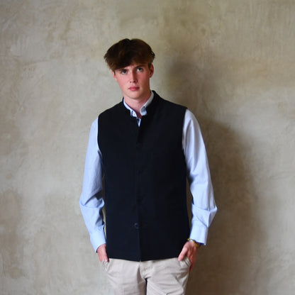 Nehru style gilet in navy moleskin. A bespoke slim-fit gilet in a pure cotton navy moleskin fabric handmade for you in London. Shown worn closed over blue shirt.