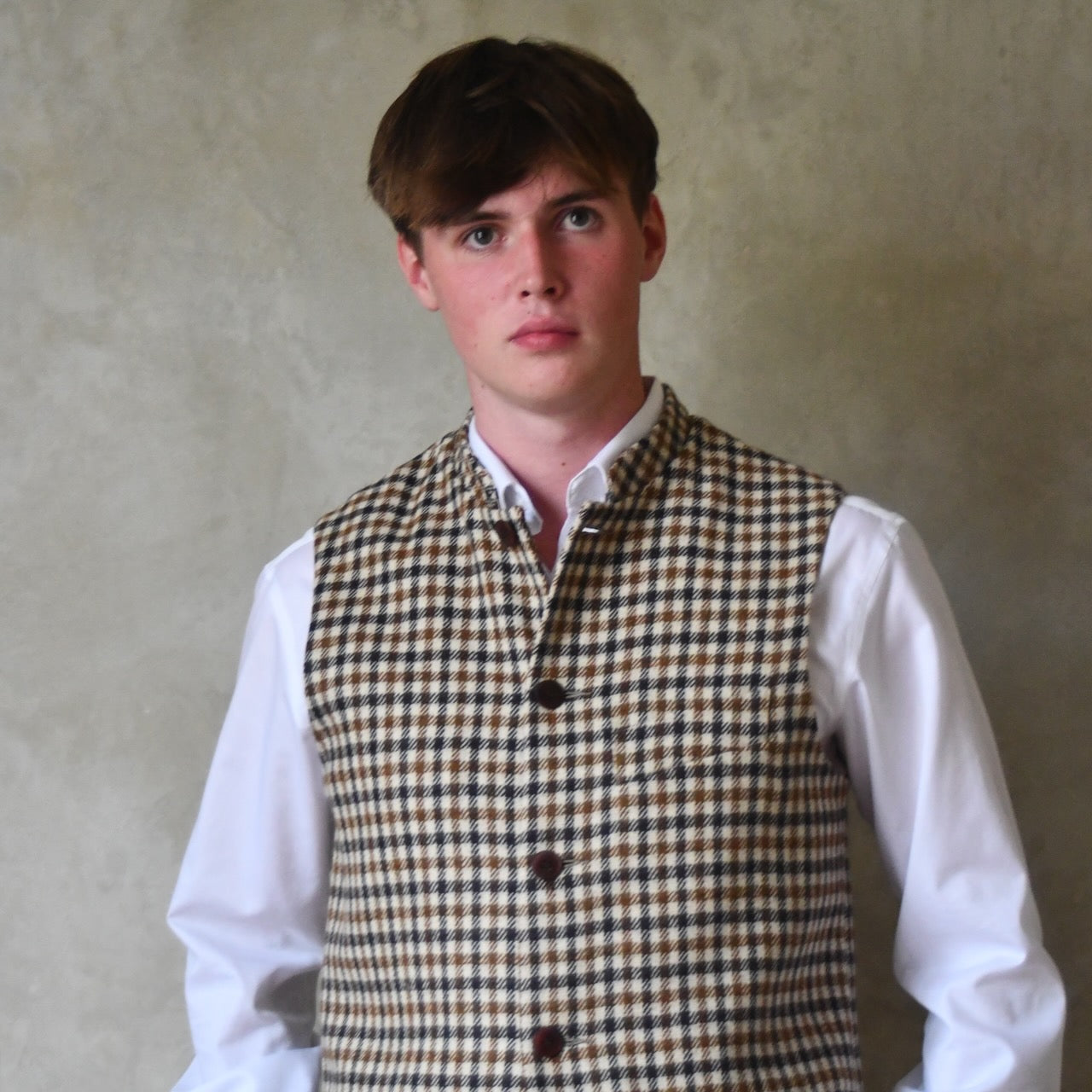 Loose Fit Nehru-style gilet in pure wool checked tweed. This gunclub check tweed waistcoat has a softer than usual feel, being made from fabric woven in Somerset. Handmade in London these waistcoats can be ordered in size 26 to 54 and bespoke sizes.