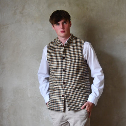 Loose Fit Nehru-style gilet in pure wool checked tweed. This gunclub check tweed waistcoat has a softer than usual feel, being made from fabric woven in Somerset. Handmade in London these waistcoats can be ordered in size 26 to 54 and bespoke sizes.
