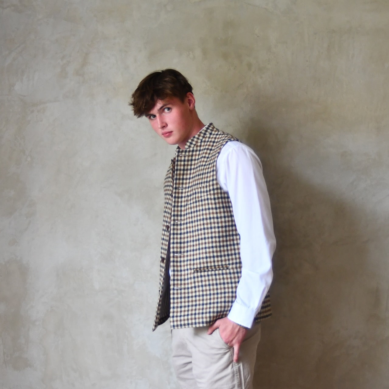 Loose Fit Nehru-style gilet in pure wool checked tweed. This gunclub check tweed waistcoat has a softer than usual feel, being made from fabric woven in Somerset. Handmade in London these waistcoats can be ordered in size 26 to 54 and bespoke sizes.