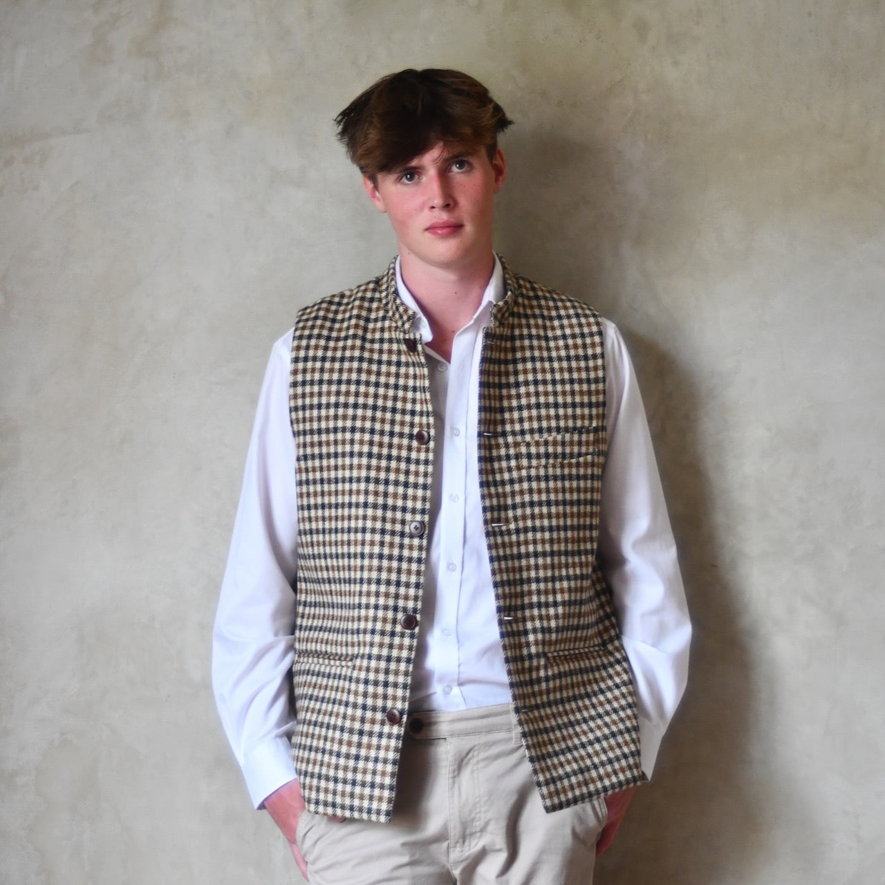 Fitted Nehru-style gilet in pure wool tweed. This gunclub check tweed waistcoat has a softer than usual feel, being made from fabric woven in Somerset. Handmade in London these waistcoats can be ordered in size 26 to 54 and bespoke sizes.