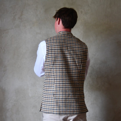 Rear view of Fitted Nehru-style gilet in pure wool tweed. This gunclub check tweed waistcoat has a softer than usual feel, being made from fabric woven in Somerset. Handmade in London these waistcoats can be ordered in size 26 to 54 and bespoke sizes.