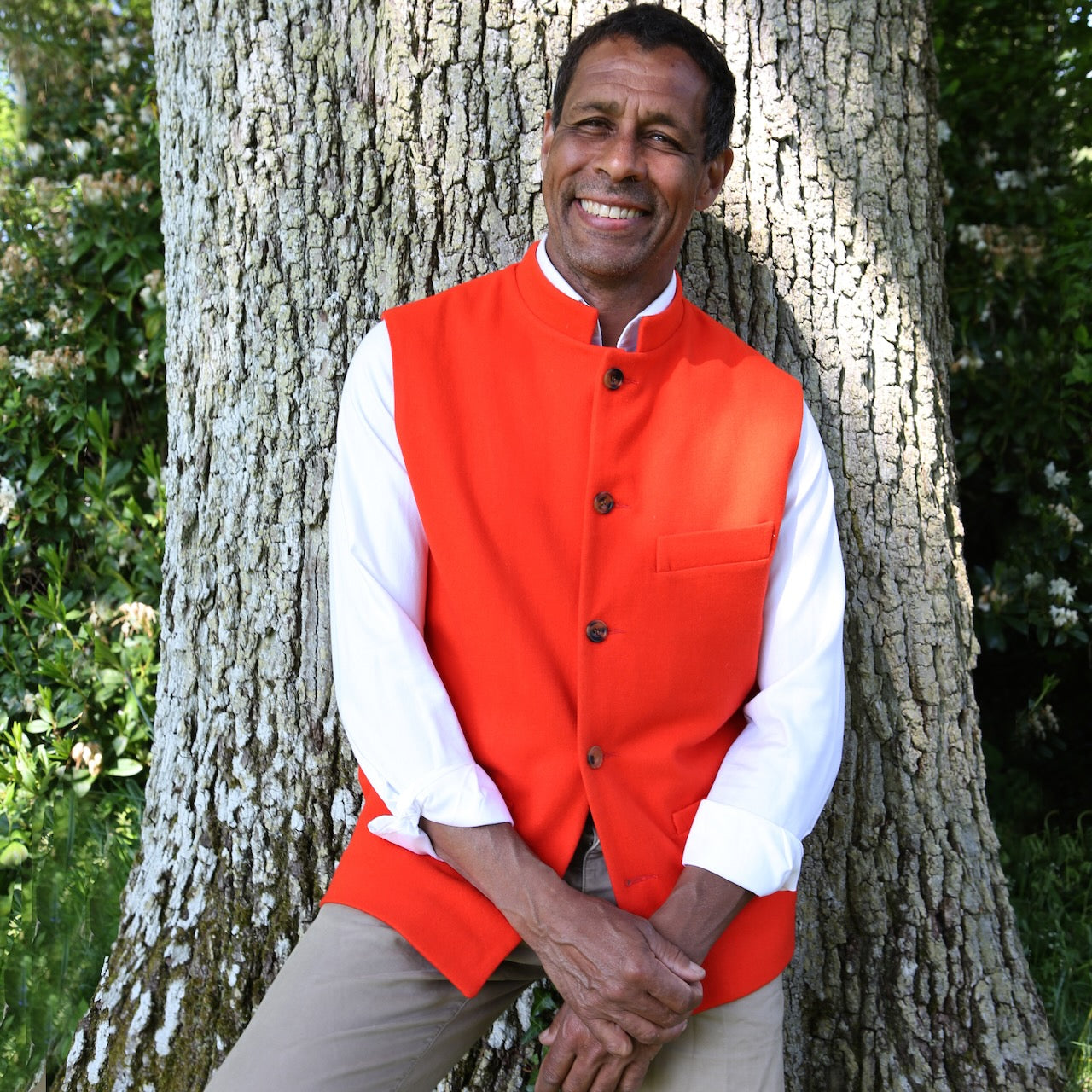 A bright orange Nehru Style Gilet in pure merino wool flannel. Woven in Yorkshire this merino melton has a wonderful handle and a lovely warm weight to it. Handmade in London, this gilet has three outer and two inner pockets and side vents for ease when seated.
Cut,  Made and Finished by Hand in London. Woven in Yorkshire, with buttons from Gloucestershire - a truly British Waistcoat.