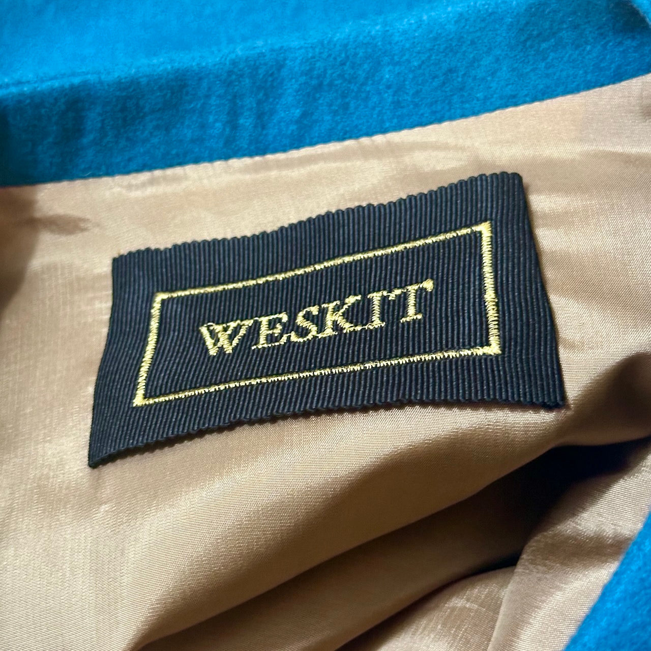 A superb and wonderfully warm alternative to a jacket for autumn winter in a luxurious pure merino wool flannel with a neat cut and ample pocket space. Woven in Yorkshire. Handmade in London. Buttons from Courtney & Co in Gloucestershire. Detail shot showing inside collar, embroidered silk lining and  Low Nehru Collar.