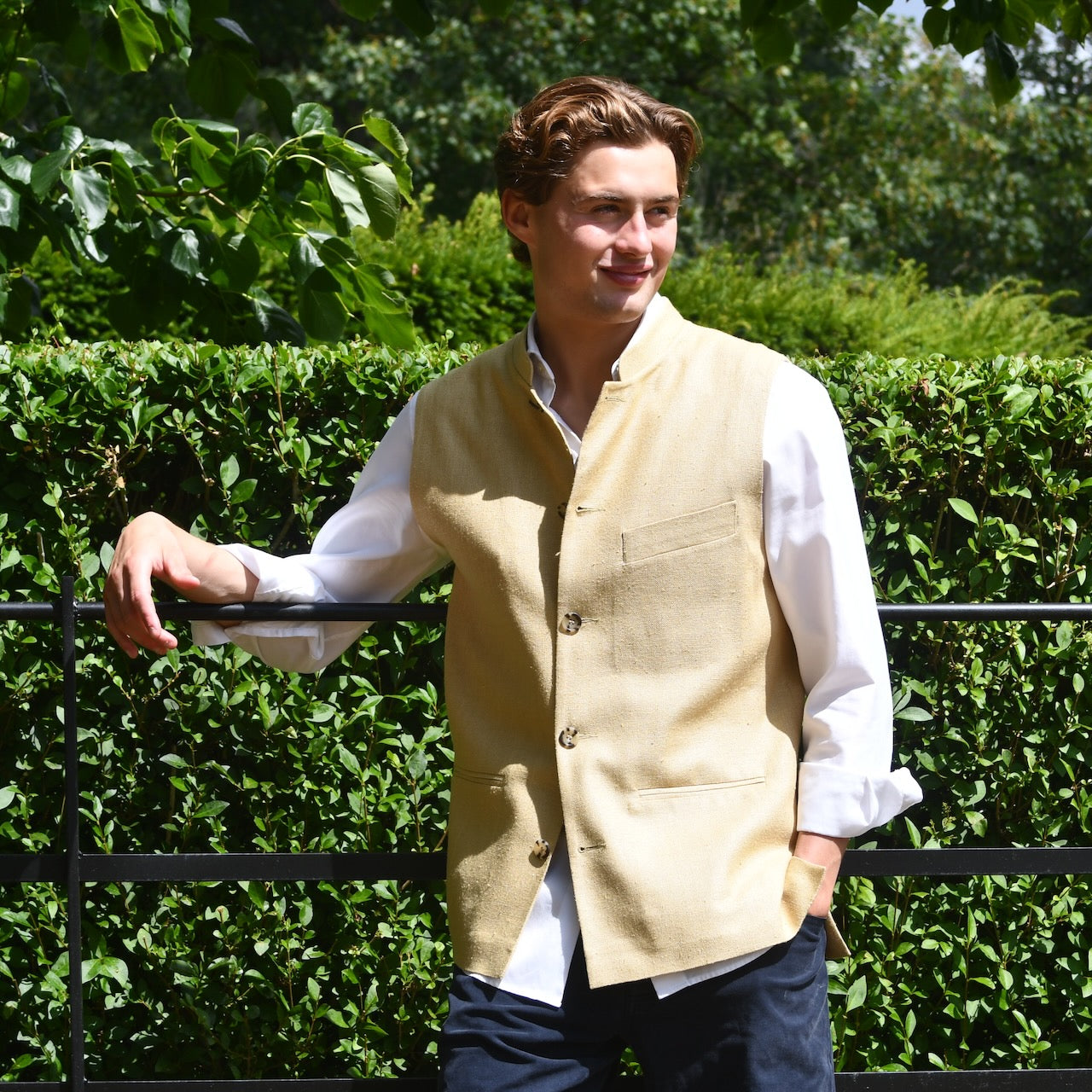 Lighter weight fitted gilet in sandy straw coloured silk weave fabric. Handmade in London this Nehru style gilet boast a Nehru collar, five pockets and is fully lined in pure cotton ticking. Front Butoned Shot.
