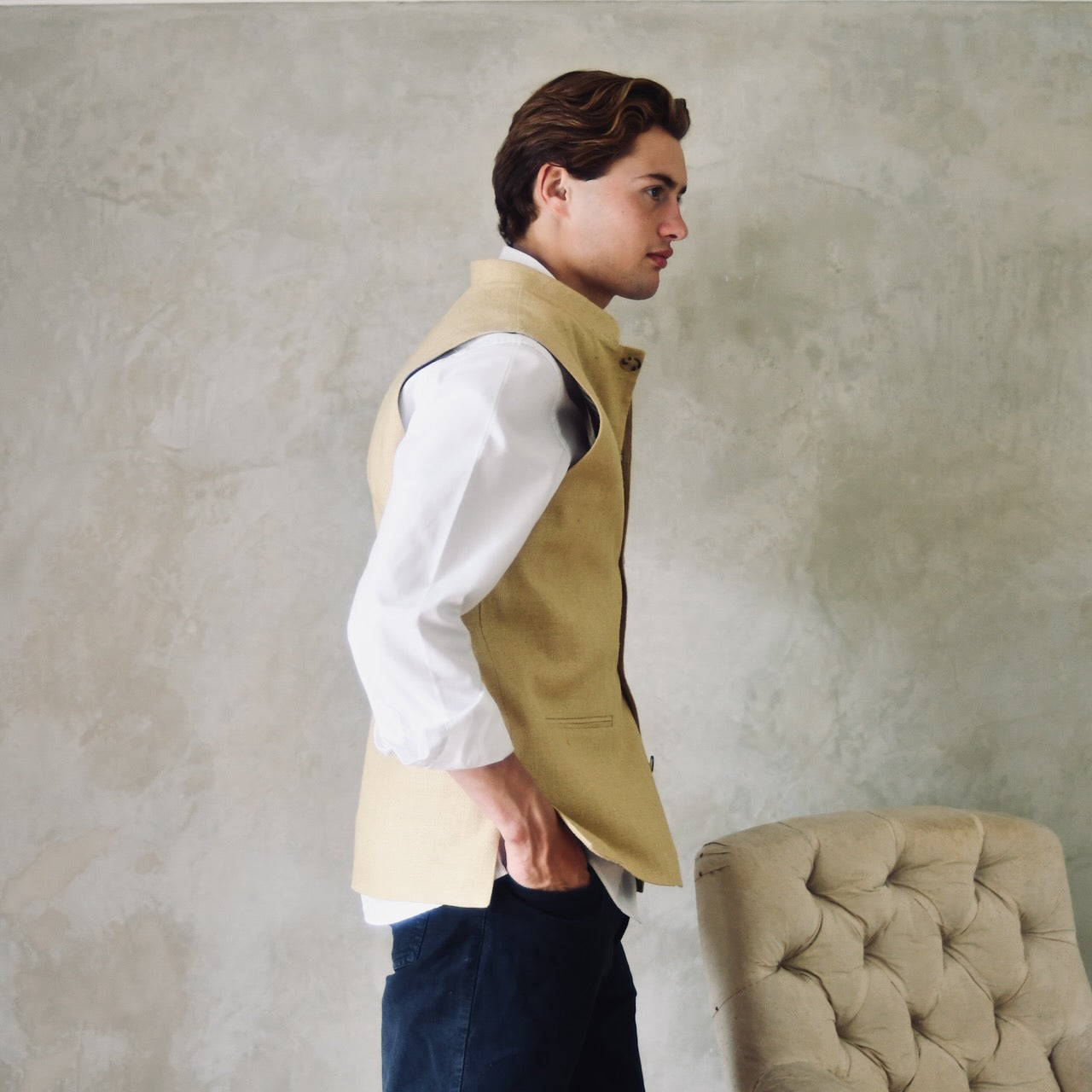 Lighter weight fitted gilet in sandy straw coloured silk weave fabric. Handmade in London this Nehru style gilet boast a Nehru collar, five pockets and is fully lined in pure cotton ticking. Side Shot.