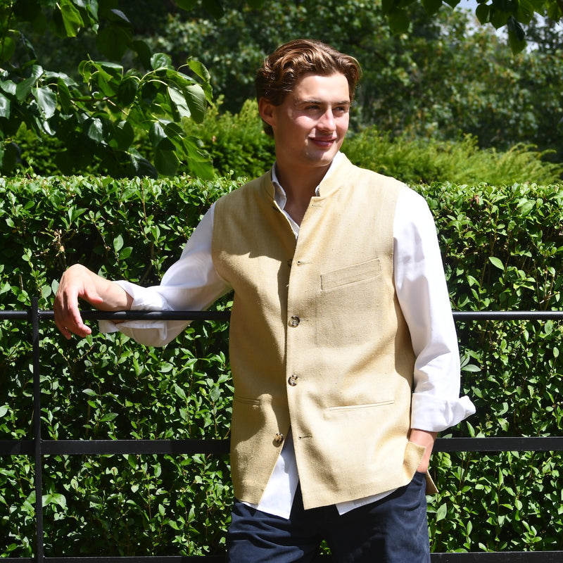 Sand Coloured Silk Matka Gilet. Handmade in London. Photographed in Wales. Shown against Estate Fencing with luscious green backdrop.