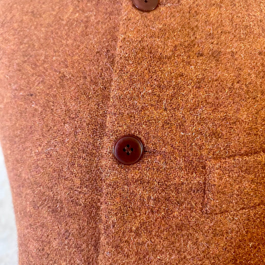 Detail Fabric Shot of  A superb alternative to a jacket or jumper in winter – especially on those cooler days. Warm and superbly smart, this thick wool gilet will work as well inside as outside and has ample pocket space.
This fitted cut has a neat five button-front, tapered darts at the rear and side vents for ease when moving and sitting. Fully lined; Handmade in Britain.
