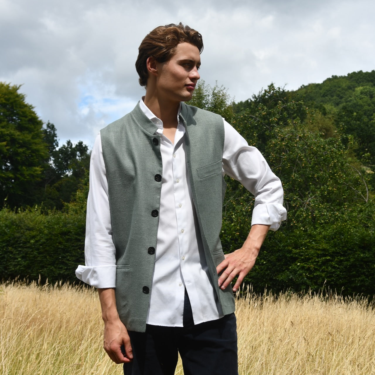 Slim cut summer weight nehru style gilet in pale green silk weave. Handmade in London this fitted waistcoat has a Nehru  collar and is fully lined in cotton ticking. Real horn buttons. Modelled unbuttoned.