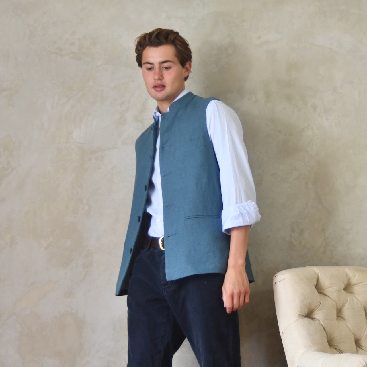 Light blue loose cut linen gilet from Weskit. Handmade in London, this slubby linen waistcoat is made in pure Irish linen and lined in striped cotton ticking. Mandarin collar and Courtney and Co buttons. Entirely made in Great Britain. Right View.