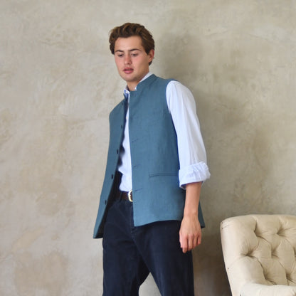 Light blue loose cut linen gilet from Weskit. Handmade in London, this slubby linen waistcoat is made in pure Irish linen and lined in striped cotton ticking. Mandarin collar and Courtney and Co buttons. Entirely made in Great Britain. Right View.