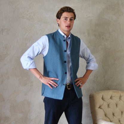 Light blue loose cut linen gilet from Weskit. Handmade in London, this slubby linen waistcoat is made in pure Irish linen and lined in striped cotton ticking. Mandarin collar and Courtney and Co buttons. Entirely made in Great Britain.