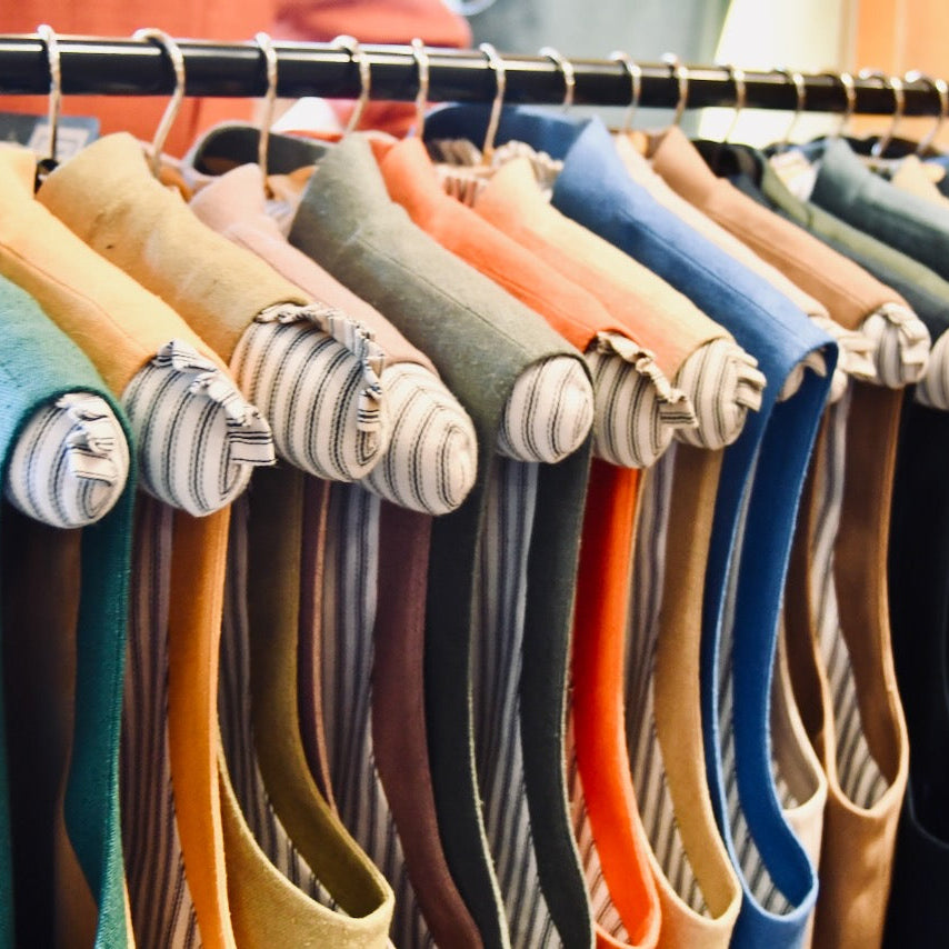 Rail of colourful silk and linen Gilets shown on custom-made rack in Weskit shop in Abergavenny. Entirely made by Hand in Great Britain.