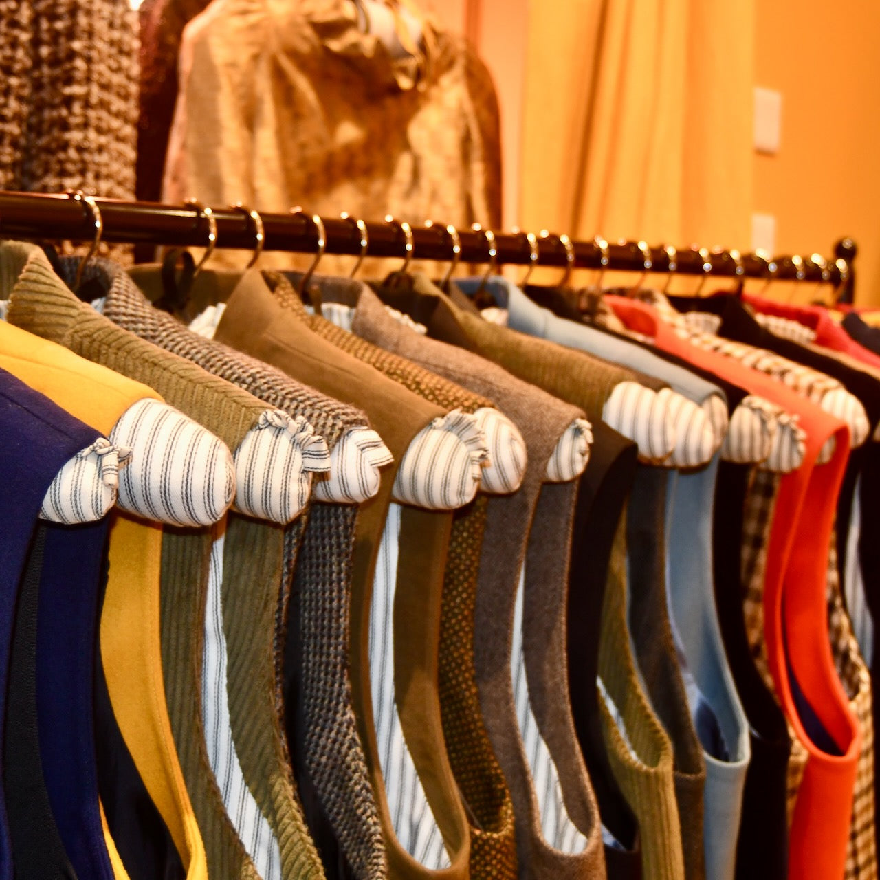 Weskit gilet shop in Abergavenny, Wales. Shot shows tweed, flannel and corduroy gilets on custom made rail.