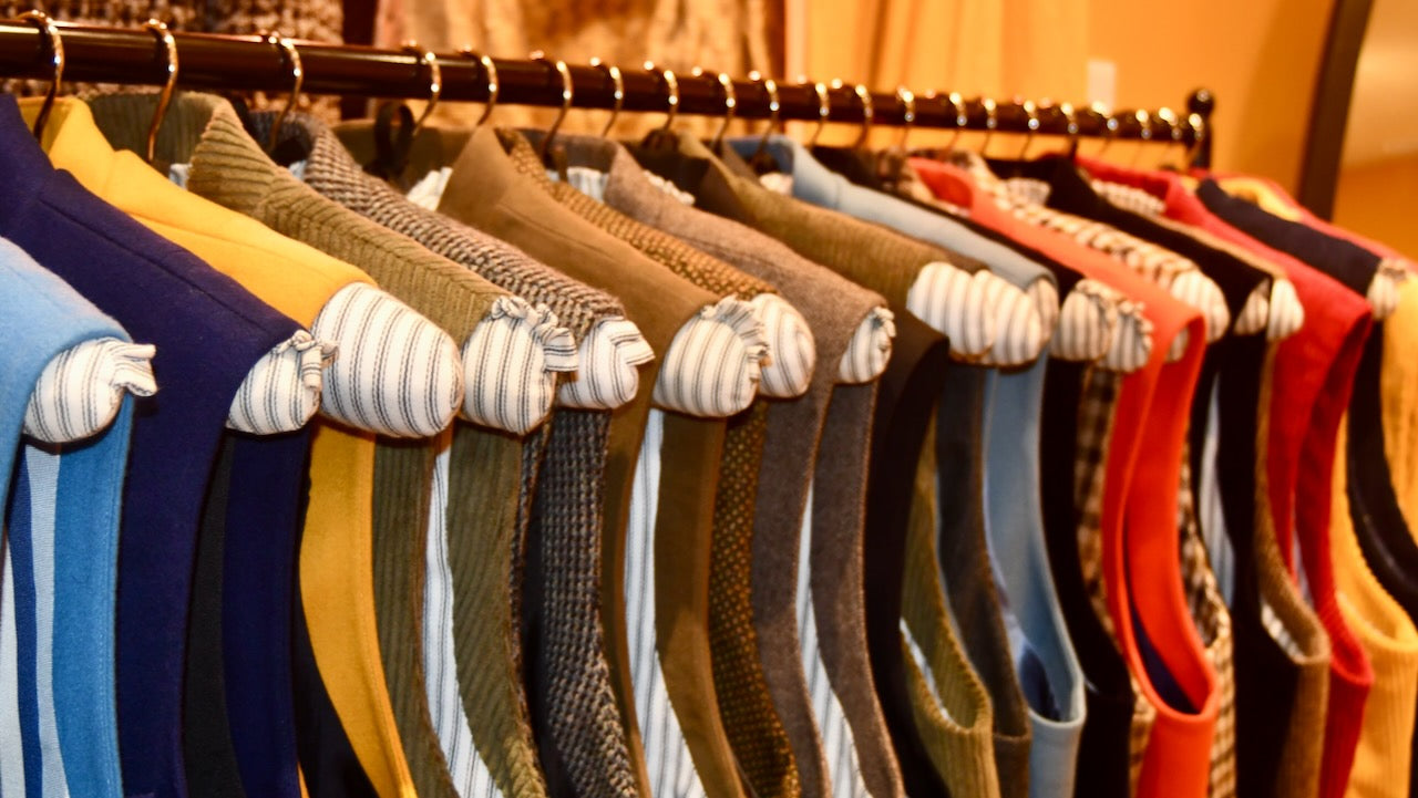 Rail of colourful tweed and flannel Gilets shown on custom-made rack in Weskit shop in Abergavenny. Entirely made by Hand in Great Britain.