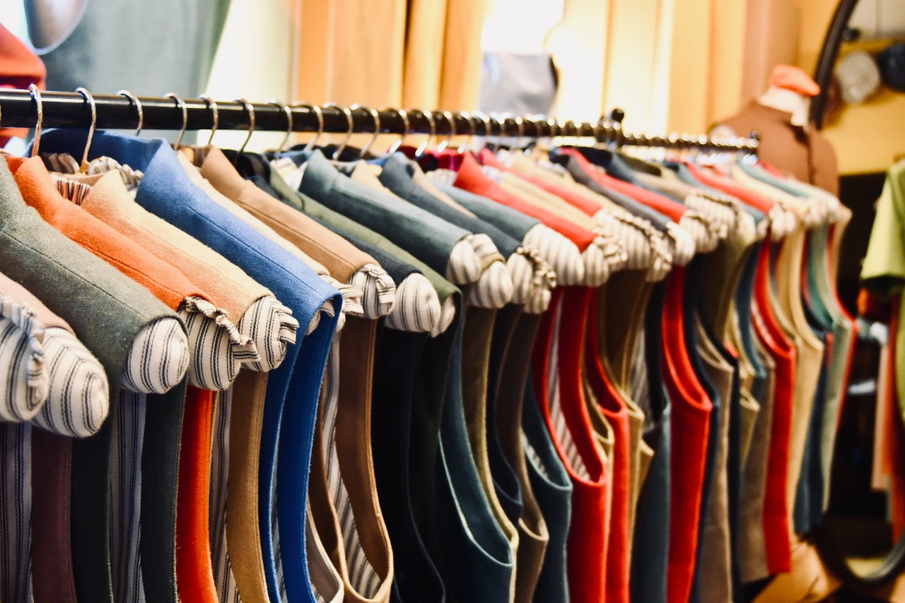 Rail of colourful silk and linen Gilets shown on custom-made rack in Weskit shop in Abergavenny. Entirely made by Hand in Great Britain.