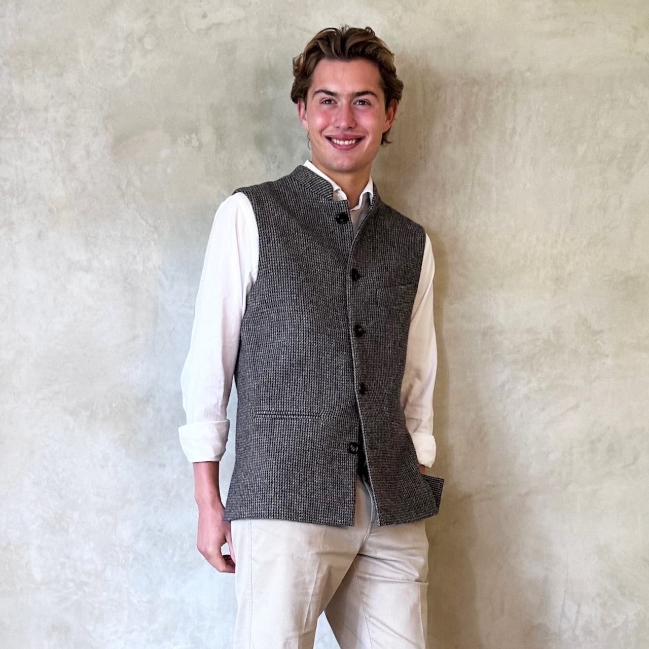 Warm Nehru Style Gilet in pure wool tweed from Hawick. Handmade in London this waistcoat has a gentle patterning in blue and shades of taupe and grey. Ample pocket space, side vents and a nead Mandarin Collar.
