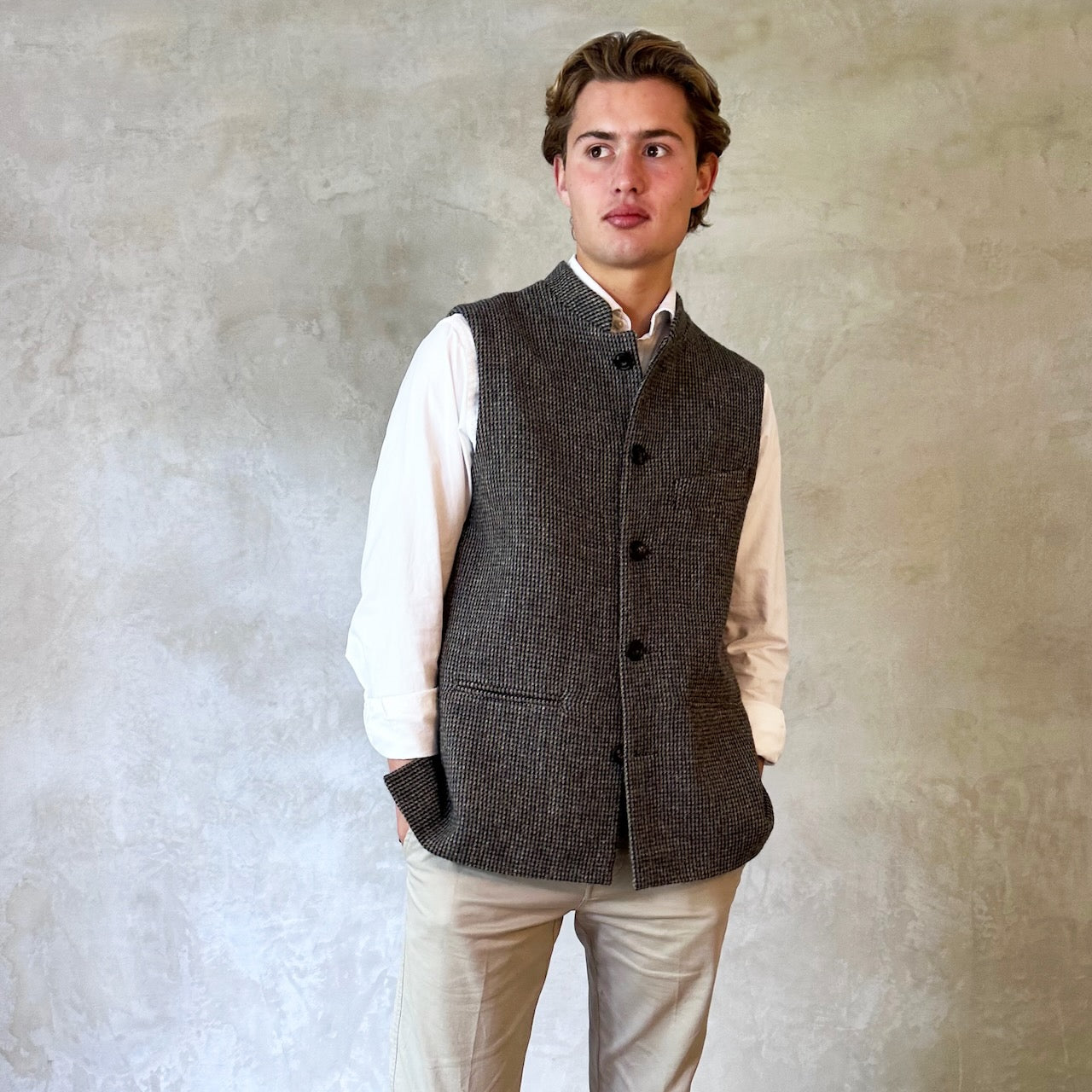 Warm Nehru Style Gilet in pure wool tweed from Hawick. Handmade in London this waistcoat has a gentle patterning in blue and shades of taupe and grey. Ample pocket space, side vents and a nead Mandarin Collar. Perfect for Winter wear.