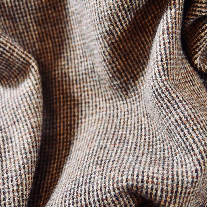Fabric detail on small brown lovat weed pattern for bespoke British made gilets by Weskit. A wonderfully warm Nehru-style gilet in a thick tweed from Hawick. Designed in Wales, oven in England, handmade in London with buttons from Gloucestershire, this is a truly British Waistcoat. Detail Shot. Side vents for ease and five pockets for storage!