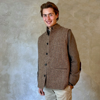 A wonderfully warm Nehru-style gilet in a thick tweed from Hawick. Designed in Wales, oven in England, handmade in London with buttons from Gloucestershire, this is a truly British Waistcoat. Detail Shot. Side vents for ease and five pockets for storage!
