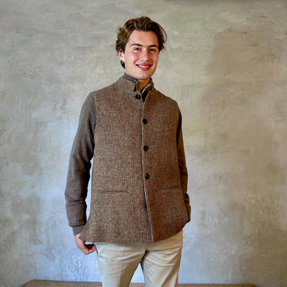 A wonderfully warm Nehru-style gilet in a thick tweed from Hawick. Designed in Wales, oven in England, handmade in London with buttons from Gloucestershire, this is a truly British Waistcoat. Detail Shot. Side vents for ease and five pockets for storage! Standing Model Shot.