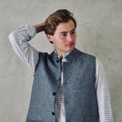 A magical limited edition mid-weight Tailored Cut waistcoat in light grey and blue tiger eye tweed. This tightly woven Yorkshire tweed has an usual patterning giving the overall effect of a mid blue from a distance, it lightens and brightens up on closer inspection as the depths and vivid colours of its patterning are revealed.
Nehru Collar, Striped Ticking lining and a Flat Horn button.
Entirely made in Great Britain.